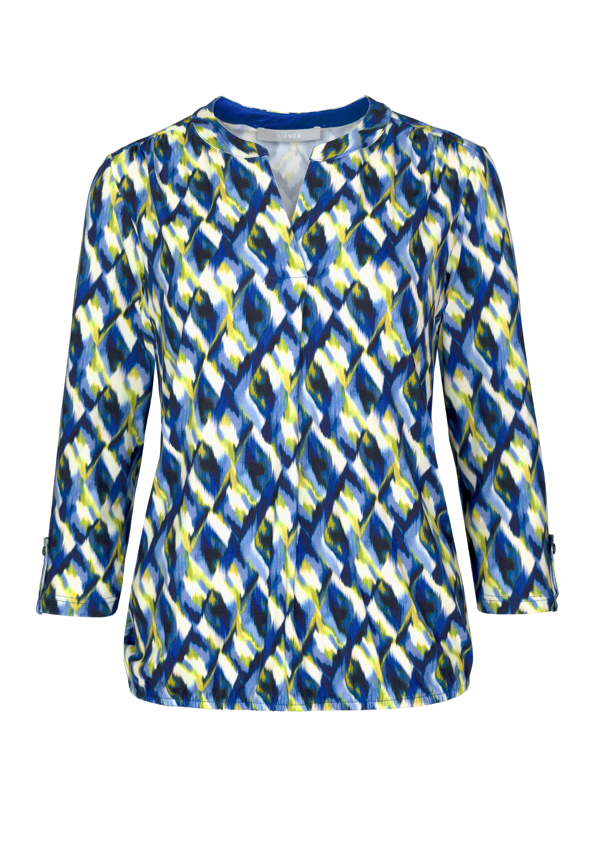 Eine Damenbluse mit Dreiviertelärmeln und einem abstrakten geometrischen Muster in Blau, Weiß, Gelb und Grün auf schlichtem weißem Hintergrund.