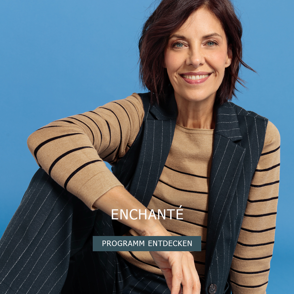 Eine lächelnde Frau mit kurzen braunen Haaren, die ein hellbraunes und schwarz gestreiftes Hemd, eine Nadelstreifenweste und eine Hose trägt, sitzt vor einem blauen Hintergrund. Der Text auf dem Bild lautet ENCHANTÉ PROGRAMM ENTDECKEN.