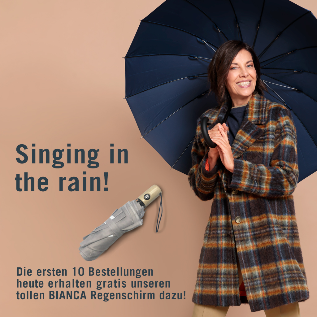 Eine lächelnde Frau in einem karierten Mantel hält einen offenen dunkelblauen Regenschirm. Text: "Singing in the rain!" und bietet den ersten 10 Bestellungen heute einen kostenlosen Bianca-Regenschirm an.