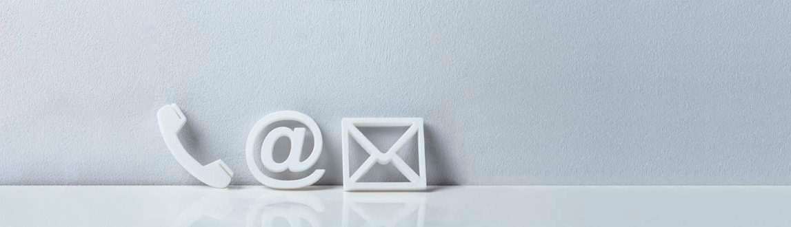 Weiße Symbole eines Telefons, eines E-Mail-Symbols und eines Umschlags sind nebeneinander auf einer glänzend weißen Oberfläche vor einem hellgrauen Hintergrund platziert.